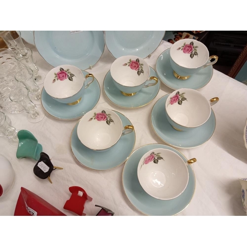 428 - A quantity of bone china cups with rose design, saucers & side plates