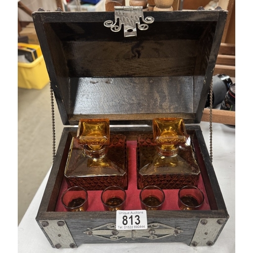 813 - A dome top treasure chest, tantalus drinks set with a pair of amber glass decanters & 4 shot glasses