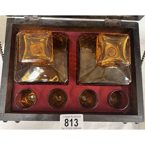 813 - A dome top treasure chest, tantalus drinks set with a pair of amber glass decanters & 4 shot glasses