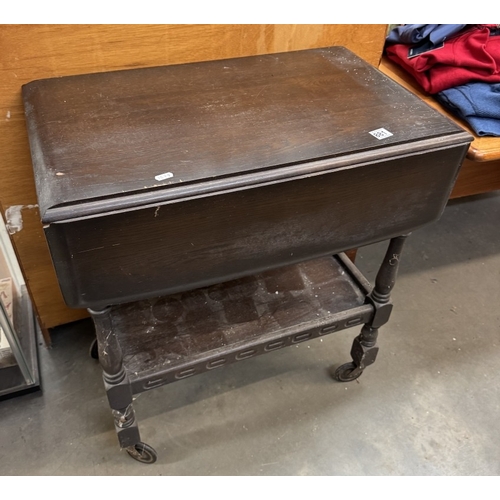 881 - A dark oak tea trolley with drop leaf top