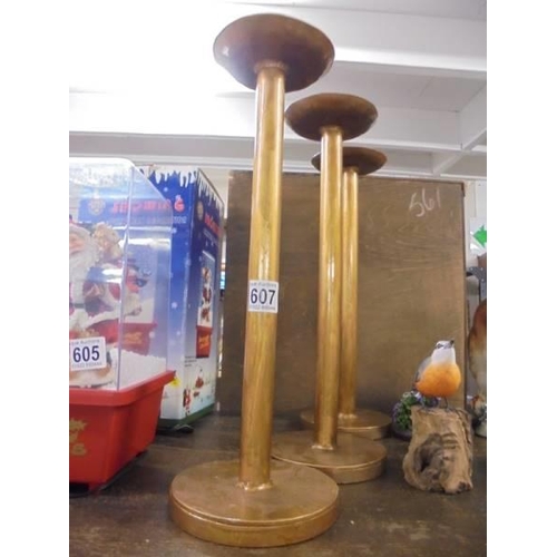 607 - Three tall gilded candlesticks.