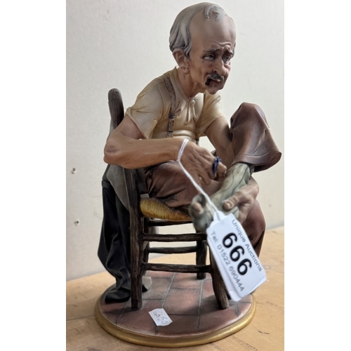 666 - A continental porcelain figure of a man darning his sock.