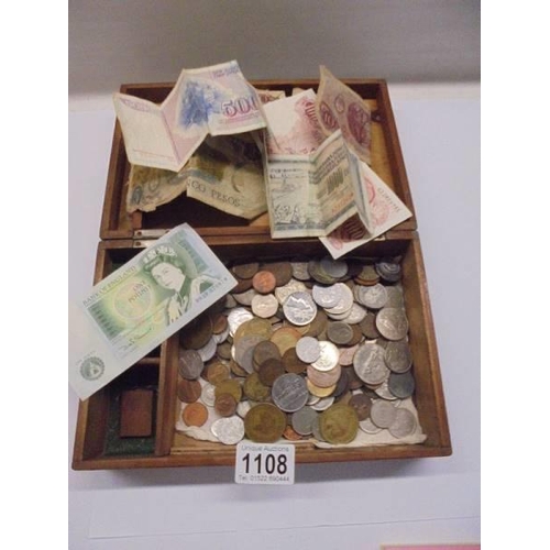 1108 - A wooden box of coins and bank notes.