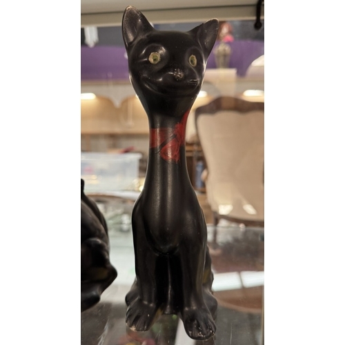 690 - A pair of vintage long neck ceramic cat ornaments. Height 23.5cm