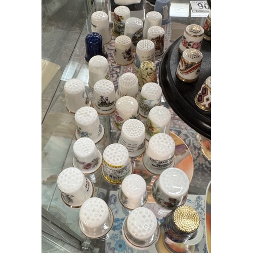 706 - A quantity of bone China thimbles including Masons, Royal Crown Derby & stand