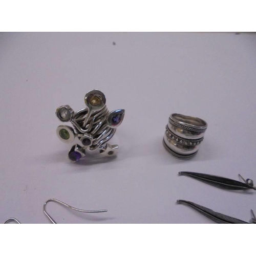 1033 - Two white metal rings and four pairs of white metal earrings.