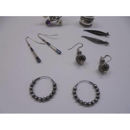 1033 - Two white metal rings and four pairs of white metal earrings.