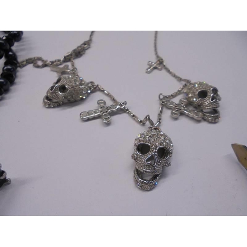 1034 - A Butler & Wilson necklace with matching earrings, a skull necklace, a skull bracelet and a cross pe... 