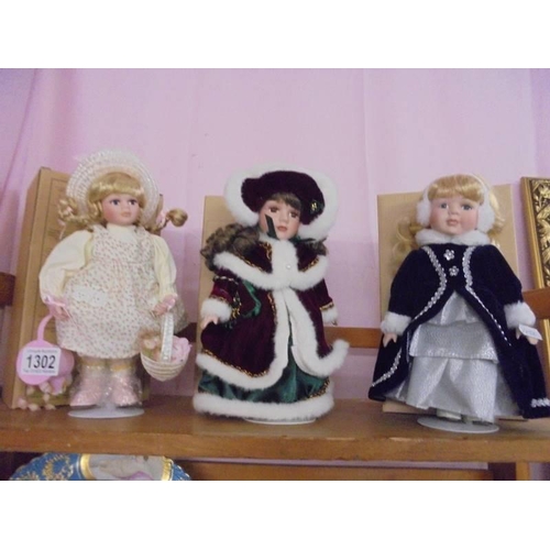 1302 - Three small boxed porcelain collector's dolls.