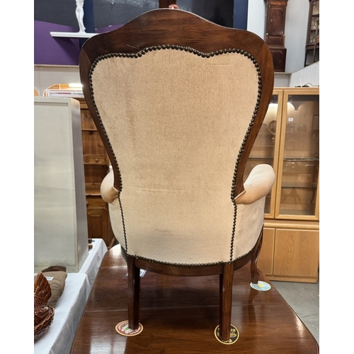 909 - An Edwardian mahogany framed deep buttoned wing arm chair