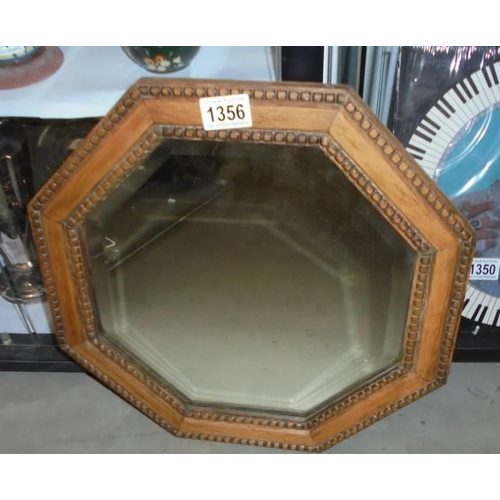 1356 - A small oxagonal oak framed bevel edged mirror. COLLECT ONLY.