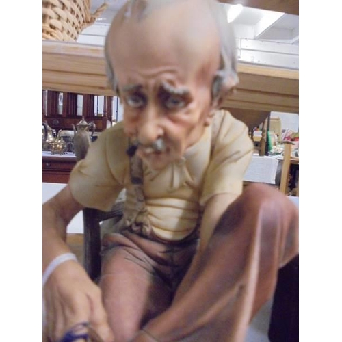 1461 - A continental porcelain figure of an elderly gentleman.