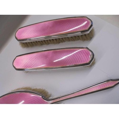 1042 - A Mappin & Webb five piece silver and pink enamel dressing table set (some minor enamel loss).