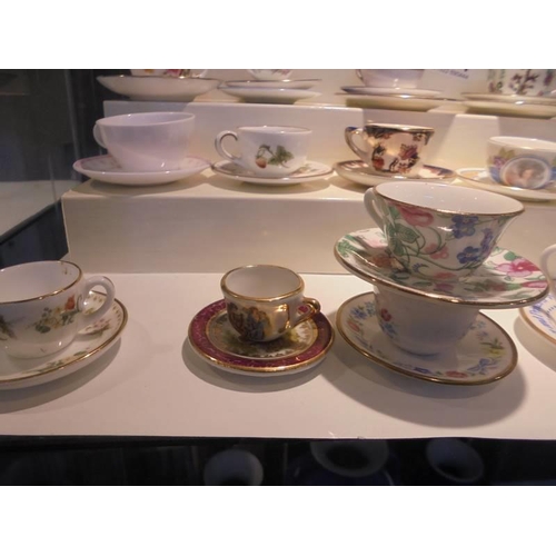 1264 - In excess of twenty miniature cups & saucers including Royal Crown Derby, Royal Doulton, Wedgwood et... 