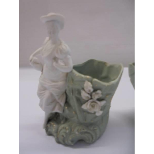 1269 - A pair of bisque porcelain figural posy vases.