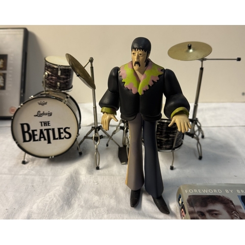 60 - A quantity of The Beatles related figures, Drum set, books, DVDs etc