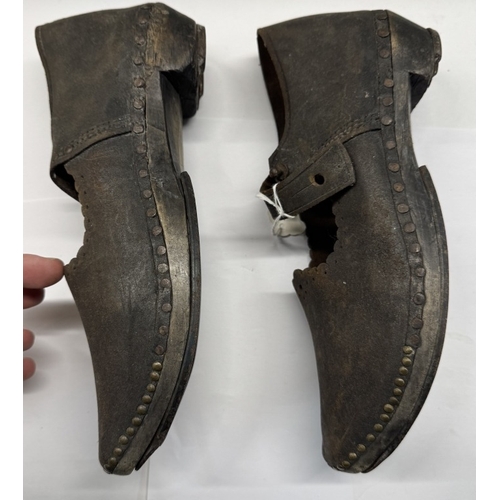 1331 - A pair of early 20th century shoes with wood and metal horse shoe shape soles and leather tops.