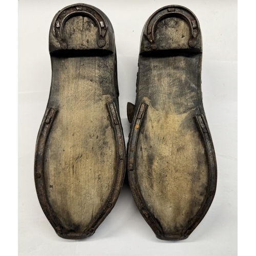 1331 - A pair of early 20th century shoes with wood and metal horse shoe shape soles and leather tops.