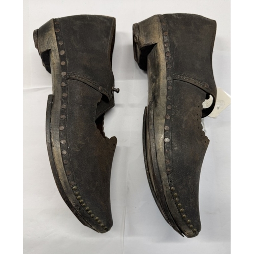 1331 - A pair of early 20th century shoes with wood and metal horse shoe shape soles and leather tops.