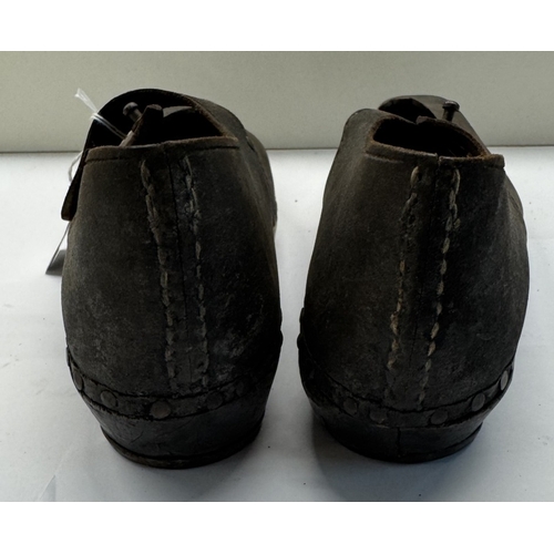 1331 - A pair of early 20th century shoes with wood and metal horse shoe shape soles and leather tops.