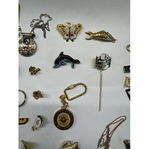 1168 - A mixed tray of costume jewellery, badges, pins, articulated fish & Chinese dragon etc.