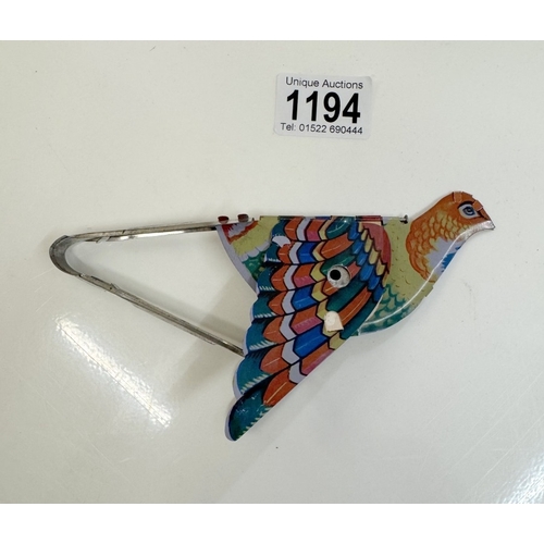 1194 - A vintage tin plate tweeting flapping squeeze tin toy bird