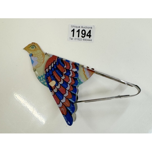 1194 - A vintage tin plate tweeting flapping squeeze tin toy bird