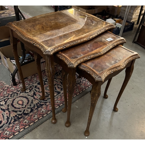 335 - A walnut veneered nest of tables with glass tops COLLECT ONLY