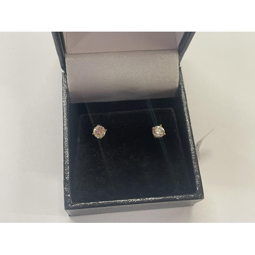 1002 - A pair of half carat diamond studs set in gold.