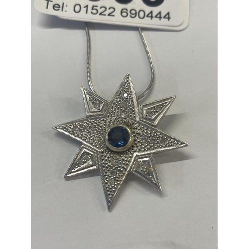 1003 - A white gold sapphire and diamond star pendant on a gold chain.