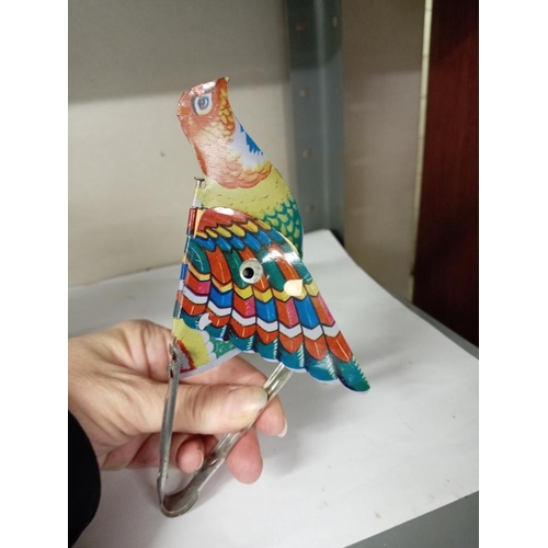 1779 - A vintage tin plate tweeting flapping squeeze tin toy bird