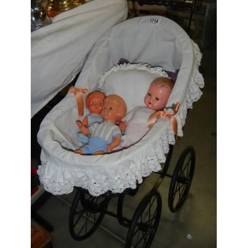 1714 - A late 20th century dolls pram with three dolls, COLLECT ONLY.