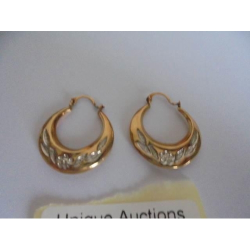 19 - A pair of 9ct gold hoop earrings engraved with flowers and foliage, 1.2 grams.