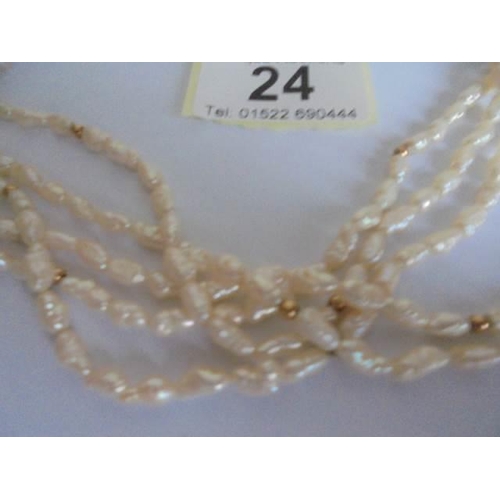 24 - A superb three strand natural pearl necklace with 14k gold clasp.