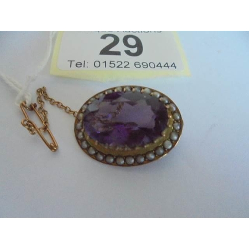 29 - A Victorian amethyst and seed pearl brooch in a 9ct gold mount with safety chain.