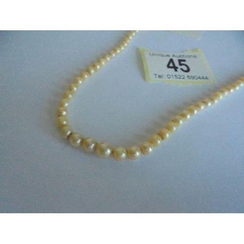 45 - A string of pearls with 9ct gold clasp.