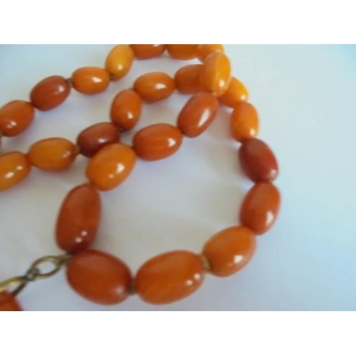 46 - An amber necklace with pendant attachment. 57.48 grams.