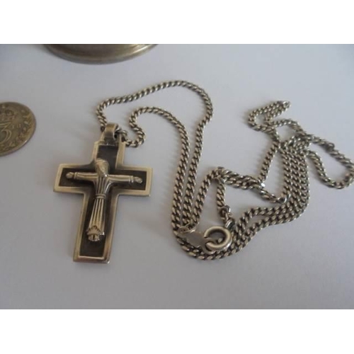 102 - Two silver napkin rings, a silver crucifix and a white metal locket on chain.