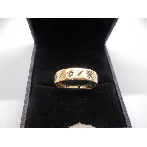 11 - A textured and worked 9ct gold band ring set with garnets and clear stones, circa 1970/80's, size O,... 