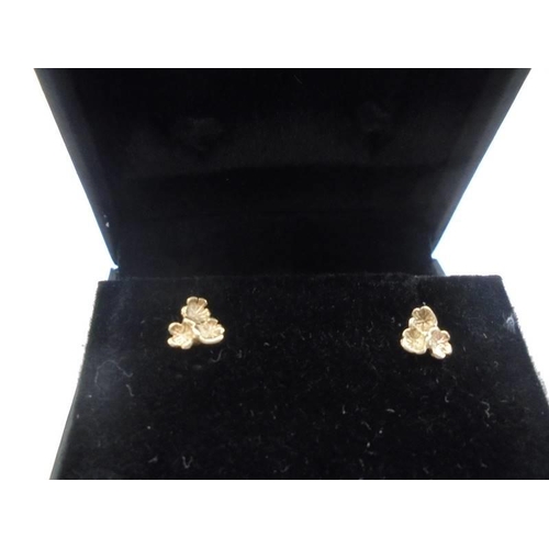 13 - A pair of 9ct gold ear studs fashioned as flower heads.