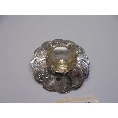 18 - A Scottish chased silver brooch with centre quartz.