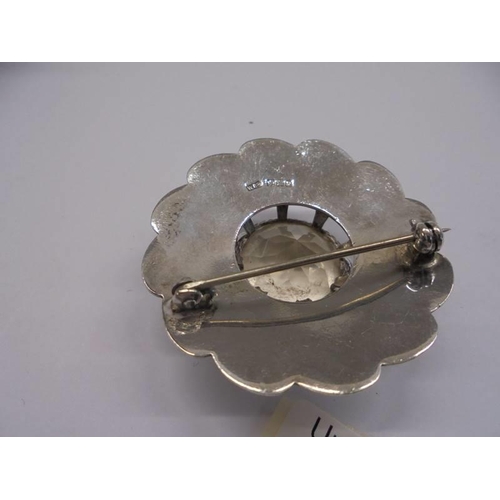 18 - A Scottish chased silver brooch with centre quartz.