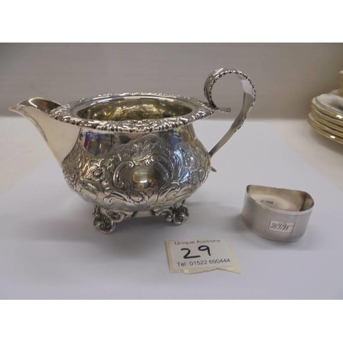 29 - A silver milk jug and a silver napkin ring.