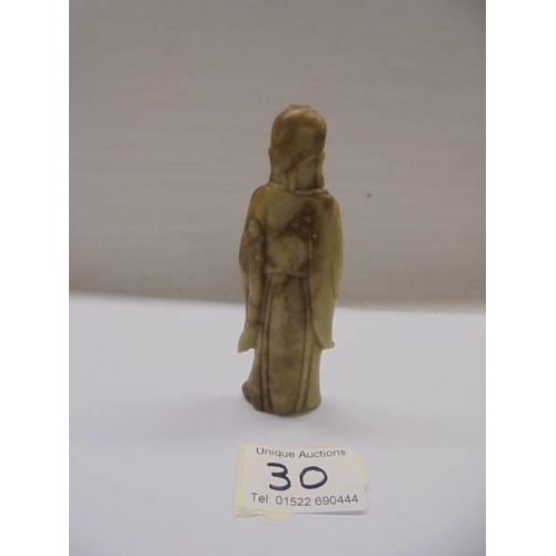 30 - A sandstone oriental figure holding a child, 11 cm.