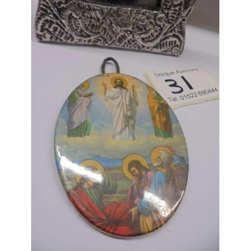 31 - An un-marked silver framed religious print and a metal oval miniature religious plaque.