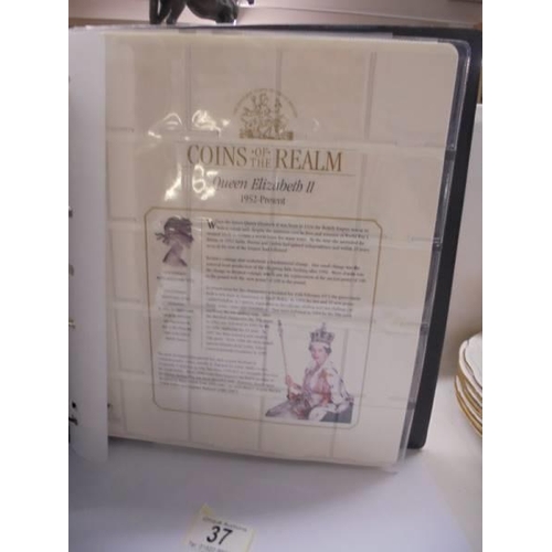 37 - A coins of the realm folder with a Queen Elizabeth II cover, a D Day cover and a replica newspaper.