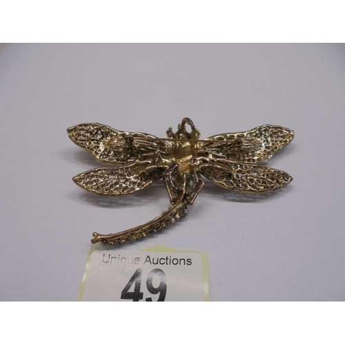 49 - A large stone set dragonfly brooch/pendant in yellow metal.