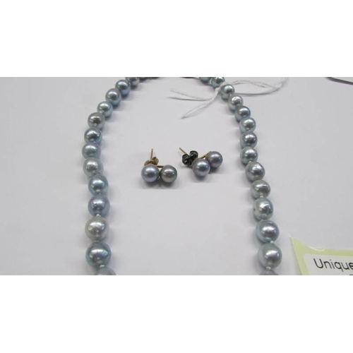 54 - A natural pearl necklace with matching earrings.