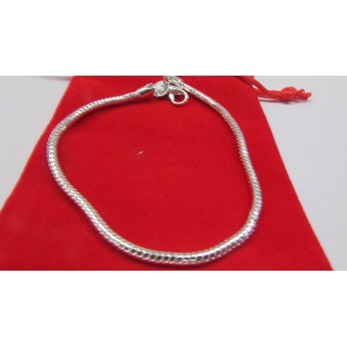 64 - A sterling silver snake bracelet with bag.