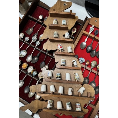 1910R - A large collection of ceramic thimbles & tourist spoons on display racks